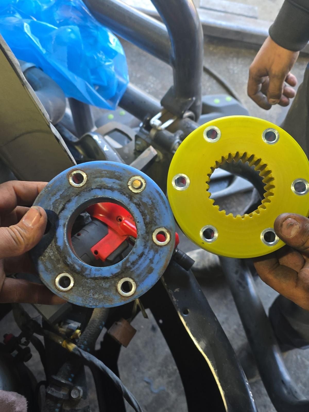 Technician’s hands holding a coupling disc during a reefer repair
